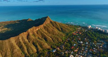 Honolulu, Hawaii, ABD 'deki Diamond Head Krateri' nin engebeli yamaçlarına yaklaşıyoruz. Dağın eteğinde yemyeşil yemyeşil bir arazi var. Hava görünümü.