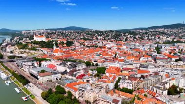 Bratislava, Slovakya 'da turuncu çatıları olan eski güzel bir kasaba. Arka planda ağaçlı dağlar. Hava görünümü.