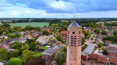 Aziz Lawrence Kilisesi saatiyle kulenin etrafında uçmak. Vierlingsbeek, Hollanda 'daki yerleşim alanının resimli manzarası.