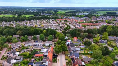 Düşük katlı evleri olan rahat bir yerleşim yeri. Hollanda 'da yemyeşil yemyeşil bir şehir manzarası. Hava görünümü.