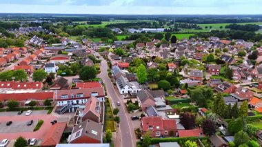 Hollanda 'nın şirin Vierlingsbeek kasabasından geçen yol üzerindeki görüntüler. Güzel yeşil çayırlar ve arka plandaki ağaçlar.
