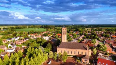 Serbest saat kulesiyle Saint Lawrence Kilisesi 'ne daha yakın uçuyor. Hollanda, Vierlingsbeek 'in güneşli manzarası.