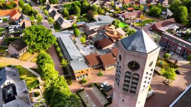 Altıgen saat kulesinin etrafındaki uçuş Saint Lawrence Kilisesi 'nin yanında serbest uçuyor. Hollanda, Vierlingsbeek 'in güzel manzarası.