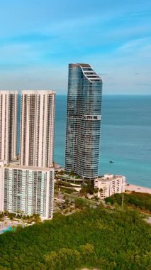 Miami 'nin mimarisinde yüksek ve alçak binaların karışımı. Arka planda muhteşem Atlantik Okyanusu olan güzel bir yerleşim yeri. Dikey video