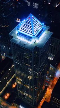 BNY Mellon Merkezi 'nin tepesinde beyaz neon ışıklı. Geceleri Philadelphia, Pennsylvania, ABD 'deki gökdelenden uzakta. Dikey video