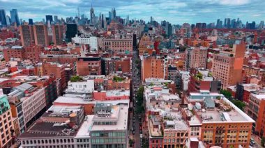 New York caddesinin yukarısına park etmiş bir sürü arabayla inin. Arkaplanda gökdelen var..