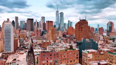Bulutlu gökyüzünün altında güzel New York şehir merkezinin silüeti. İnsansız hava aracı gündüz saatlerinde çok katlı binaların üzerinden geçiyor..