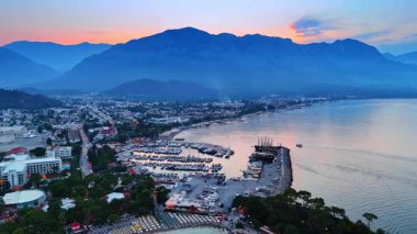 Güzel tatil beldesi Fethiye 'de alacakaranlık vakti, Türkiye. Rıhtımlarda sayısız yat var. Arkaplanda dağ siluetleri.