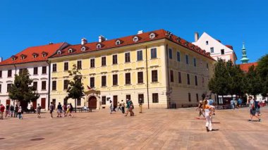 Meydanda yürüyen insanlar muhteşem mimari ile çevrili. Slovakya 'nın Bratislava kentindeki eski şehir turu.