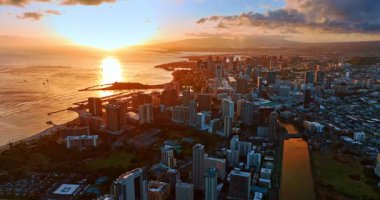Pasifik Okyanusu 'nun manzarası batan güneşten menzilli. Güzel Honolulu şehri turuncu ışıkla da kaplıdır. Gün batımında şehre hava perspektifi.