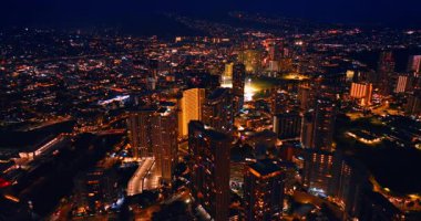 Modern, hayat dolu şehrin manzarasında milyonlarca ışık parlıyor. Fevkalade aydınlatılmış Honolulu, Hawaii, ABD 'deki insansız hava aracı görüntüleri..