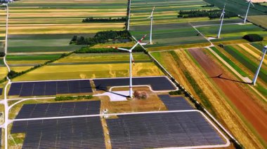 Kırsaldaki geniş alanlar yenilenebilir enerji üretimi için kullanılıyor. Rüzgar türbinleri ve güneş panelleri üzerinde hava perspektifi.