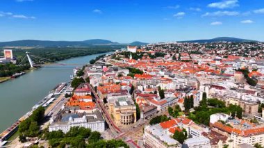 Tuna 'nın rıhtımındaki eski tarz binaların üzerinden uçacağız. Eski kasabadaki Bratislava Kalesine yaklaşıyoruz..