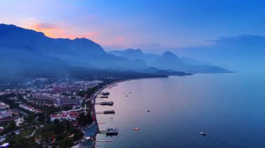 Sahilleri ve yatakları olan güzel bir tatil köyü. Arka plandaki dağların siluetleri. Akdeniz, Türkiye.