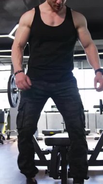 Spor salonunda çalışan bir adam. Vücut geliştiren yakışıklı adam spor salonunda egzersiz yapıyor.