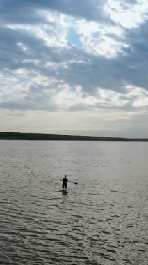 Kürek çekme masasında dinlenen bir çift. Dik raket tahtasında rahatlayan çiftin drone görüntüsü