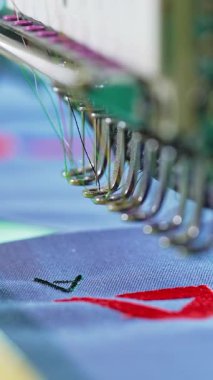 Profesyonel ve endüstriyel nakış makinesi. Giyim fabrikasındaki otomatik dikiş makinelerini kapatın.