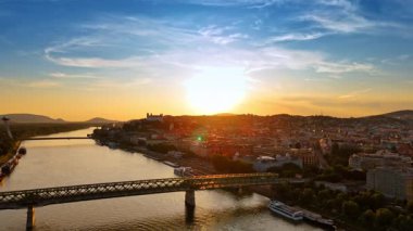 Slovakya 'nın Bratislava kasabasına giden Eski Köprü' ye yaklaşıyoruz. Batan güneş manzarayı sersemletir. Hava görünümü.