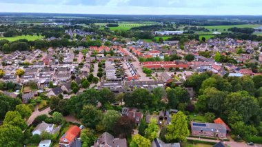 Sakin banliyö hava manzarası. Geniş manzaralı evler, yeşil alanlar ve gün ışığında temiz sokaklar..