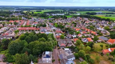 Sıcak kırsal alandaki sevimli evlerin üzerinden uçacağız. Hollanda, Vierlingsbeek 'in verimli yeşilliği.
