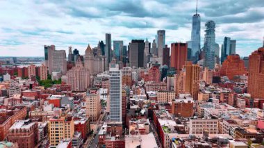 Yoğun bir kentsel alanda ince, yüksek katlı bir binaya yaklaşıyoruz. Arkadaki gökdelen silueti. New York, ABD.