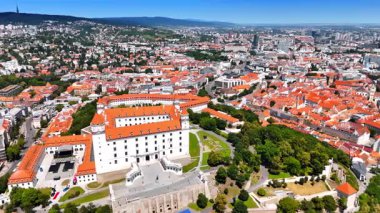 İnsansız hava aracından Bratislava Kalesi 'ne göz kamaştırıcı bir manzara. Bölgedeki yeşil bahçeler. Arkaplanda şehir panoraması.