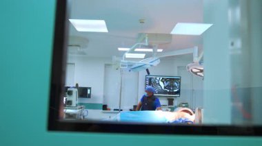 Cerrah ameliyata hazır. Bir tıp uzmanının ameliyat için hazırlandığı gün ışığında ameliyat odasında önlükle görülmektedir..