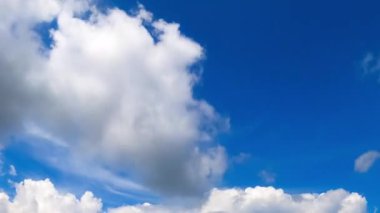 Bulutlar gökyüzünde zaman kaybına uğrar. Bulutlar parlak mavi gökyüzünde hızla sürükleniyor, dinamik bir hareket sergiliyor..