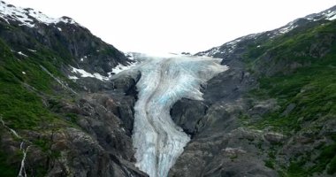 Dağların arasındaki çatlakta bir buzul. Alaska 'daki insansız hava aracı görüntülerinden donmuş nehir.