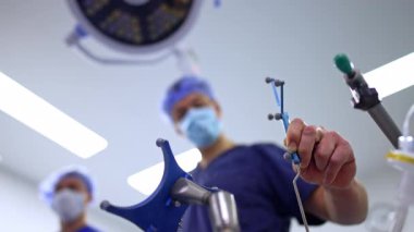 Erkek el nöroşirürji sondası tutuyor. Kapatın. Doktorun beyin ameliyatı yaparken düşük açılı görüntüsü..