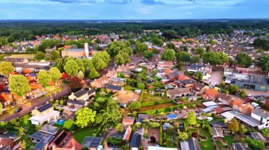 Canlı bir banliyö mahallesi. Hava manzarası öğleden sonra geç saatlerde evleri ve bahçeleri olan yemyeşil bir banliyö gösteriyor..