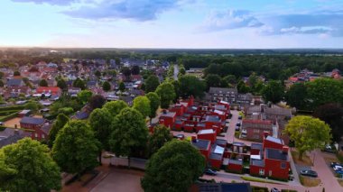 Modern tasarımı olan canlı bir alan. Alacakaranlık sırasında yemyeşil yeşilliklerle çevrili modern evlerin olduğu renkli bir mahalle manzarası..