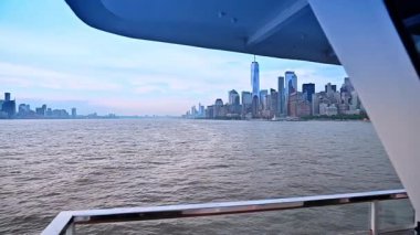 Nehir teknesinin güvertesinde duruyor. Doğu Nehri 'nden geçiyor. New York, ABD 'de Manhattan' ın mimarisine bakın.
