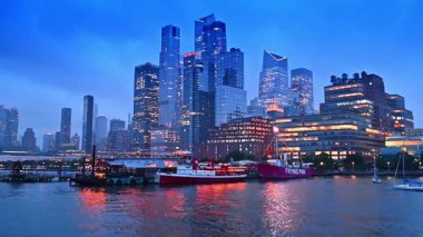 Güzel aydınlatılmış tekneler, rıhtım ve rıhtımdaki binalar. Alacakaranlıkta New York 'ta Hudson Nehri' nin kıyısında seyahat etmek.
