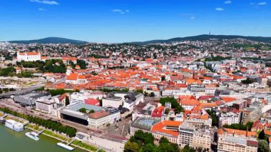 Slovakya 'nın Bratislava kentindeki günışığı manzarası. Tarihi bölgenin turuncu çatılarının üzerindeki insansız hava aracı görüntüleri..