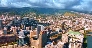 Modern Honolulu Panoraması, Hawaii, ABD. Manzarayı çevreleyen yeşil dağlar. Gökyüzünde dramatik bulutlar. Hava görüntüsü.