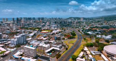 Şehir bölgesini geçen yoğun otoyol üzerinden uçuş. Waikiki 'nin yüksek gökdelenli silueti.