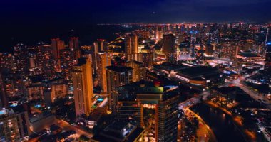 Waikiki, Honolulu, Hawaii, ABD 'deki güzel gökdelenlerin üzerinde uçuyor. Geceleri şehrin şaşırtıcı, ışıltılı manzarası..