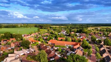 Hollanda 'da güzel bir kasabanın yeşil güneşli manzarası. Gökyüzünde ağır kabarık bulutlar. Hava görünümü.