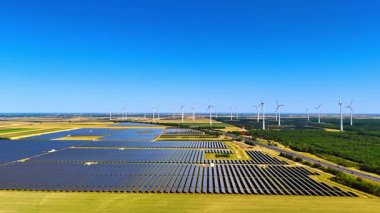 Kırsal bölgede alternatif enerji kaynakları var. Rüzgâr çiftlikleri ve kırsal alandaki güneş panelleri hava perspektifinden.