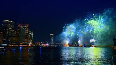 Fevkalade havai fişekler nehri ve binaların cephelerini yansıtıyor. Gece vakti New York 'ta muhteşem bir kutlama..