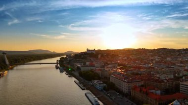 Tuna nehrinin üzerinde yükseliyor. Slovakya 'nın Bratislava kentinin günbatımındaki manzarasını gözler önüne seriyor..