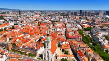 Turuncu çatıları olan eski kasabadaki kilisenin tepesine yaklaşıyoruz. Bratislava, Slovakya 'nın tarihi bölümünün insansız hava aracı görüntüleri.