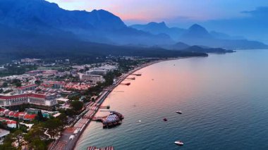 Gün batımında güzel bir tatil köyü. Türkiye 'nin Kemer Denizi sahilinde insansız hava aracı uçuşu.