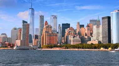 Modern New York 'un ufuk çizgisi üzerinde çeşitli binalar. Nehir kıyısından geçen bir tekneden şehrin rıhtımına bak..