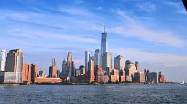 New York 'un yüksek gökdelenleri nehirden yükseliyor. Rıhtıma doğru ilerleyen bir tekne var..