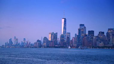Günbatımında modern New York 'un ikonik silueti. Nehir manzarasının ışıklarını açan şehre bak.