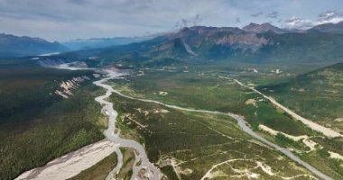 Alaska, ABD 'nin vahşi doğasının manzarası. Uçsuz bucaksız vadi, nehir ve çarpıcı dağlar üzerindeki insansız hava aracı görüntüleri..