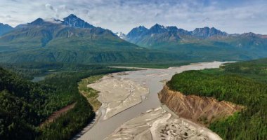 Alaska 'daki sığ nehrin geniş deltasının üzerinden uçacağız. Arkaplanda muhteşem tepeli dağlar.
