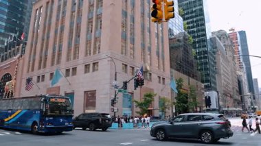 New York, ABD 'de Beşinci Cadde' de yoğun trafik var. Bir sürü insan Louis Vuitton mağazasının önünde duruyor..